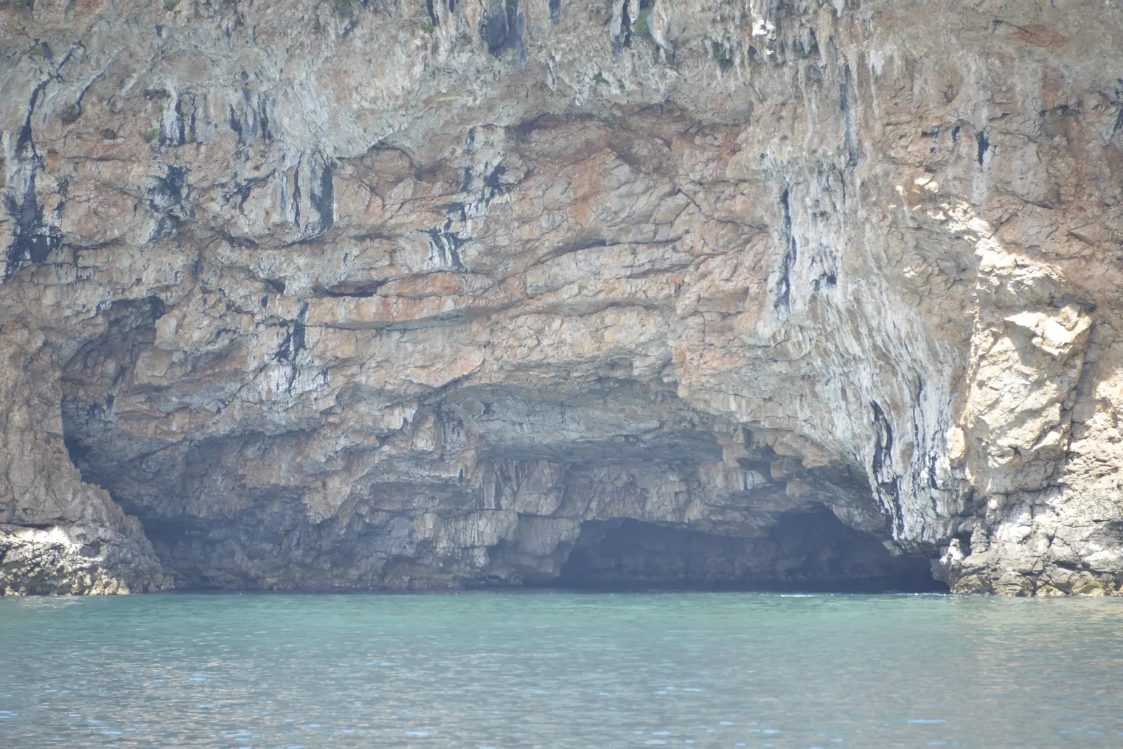 The mouth of the Blue Cave (Plava špilja) in the limestone cliffs near the Bay of Kotor, the sea glowing turquoise below