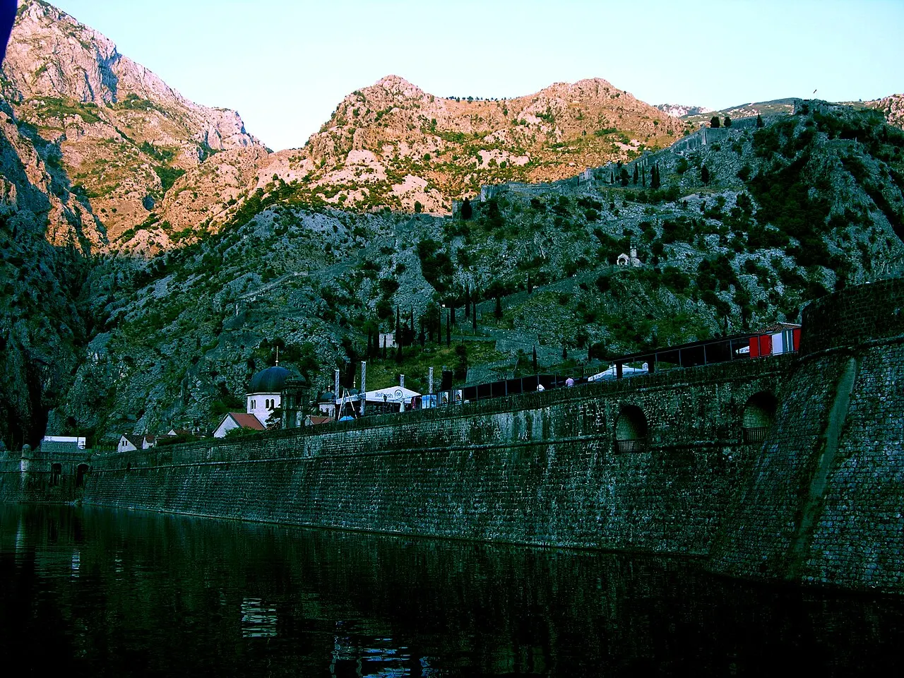 Kotor's stone city walls climbing the steep mountainside above the town, the stair-only fortification rising to the fortress
