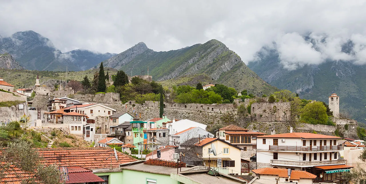 Stari Bar old town below its ruined fortress walls, stone houses and the clock tower set against the mountains