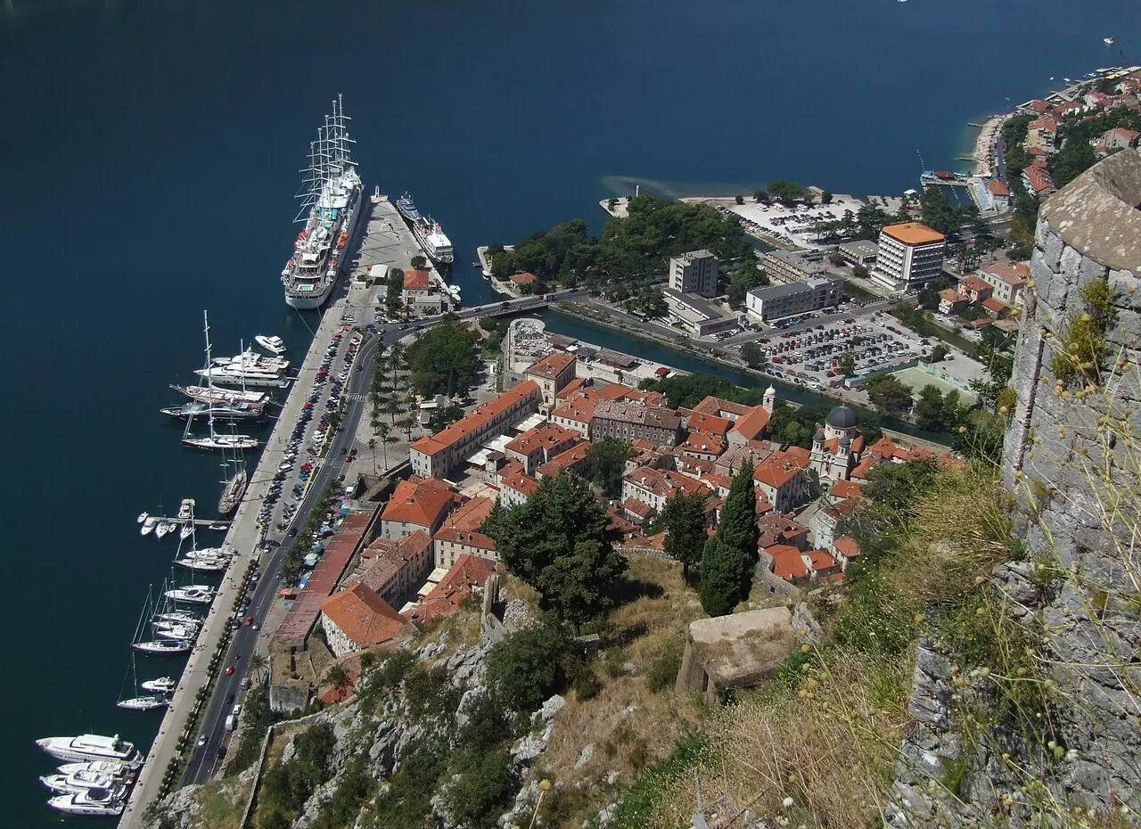 View from the Kotor city walls over the terracotta rooftops of the Old Town and the bay below the mountains