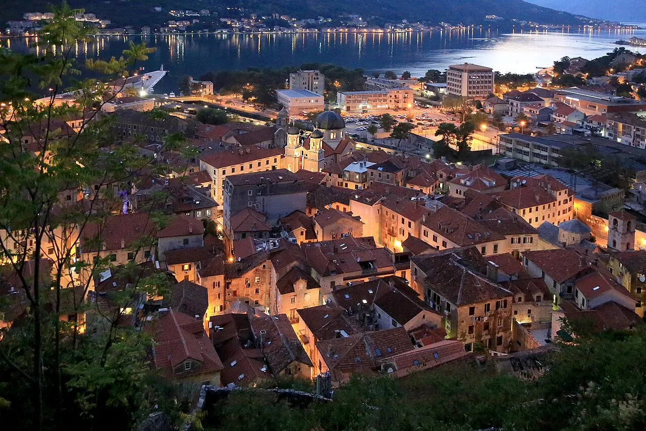 Kotor Old Town's terracotta rooftops and the glassy Bay of Kotor catching the last light at golden dusk