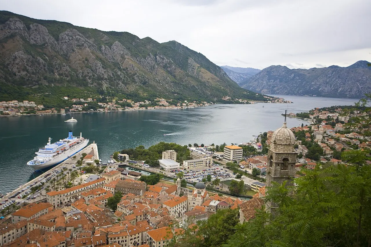 The Bay of Kotor from high on the fortress, Old Town terracotta roofs and a cruise ship below, mountains all around