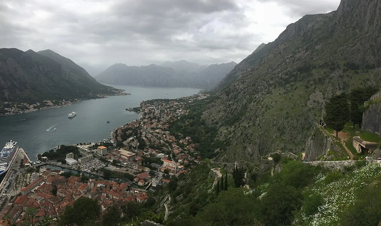 The view down from Kotor's fortress walls over the walled Old Town rooftops and the Bay of Kotor, mountains all around