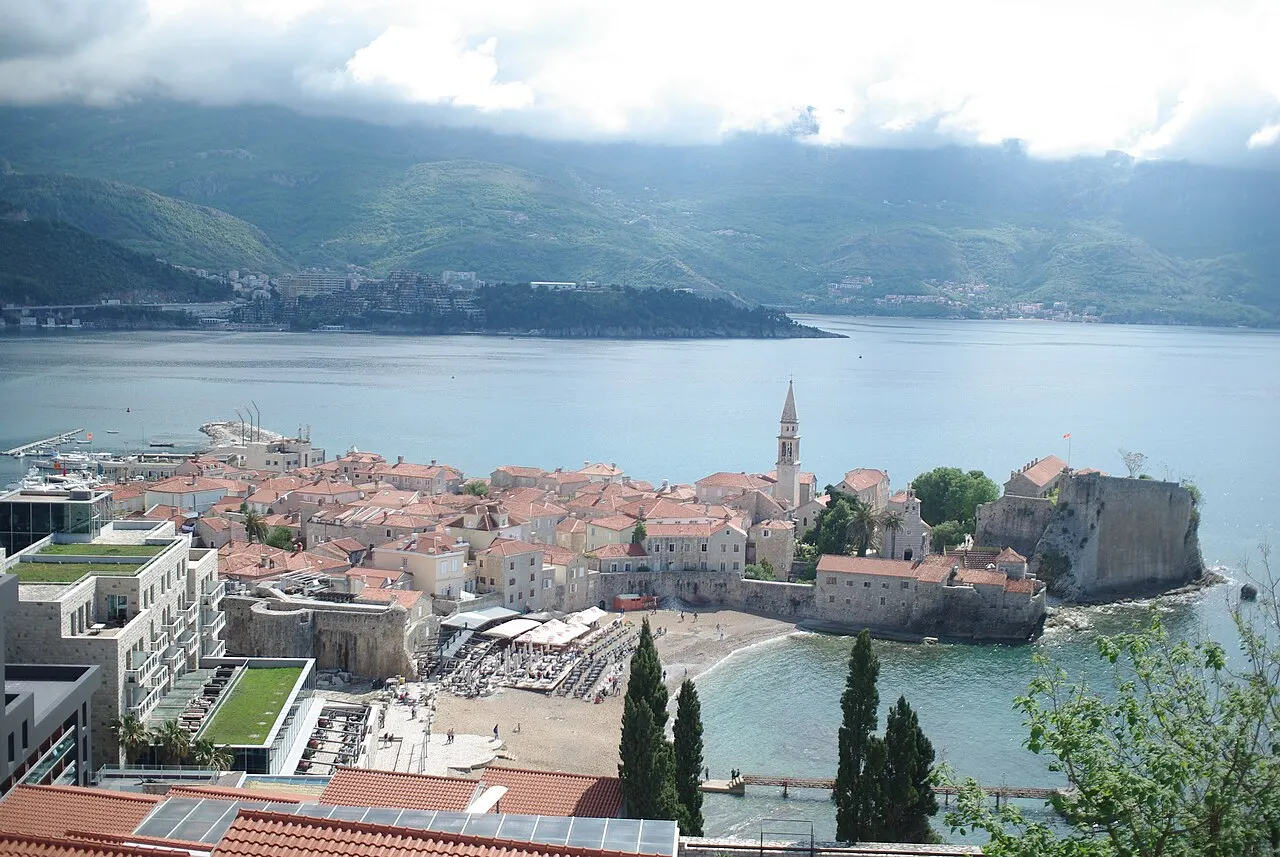 The compact walled Stari Grad of Budva on its small peninsula, terracotta roofs ringed by the open Adriatic beyond