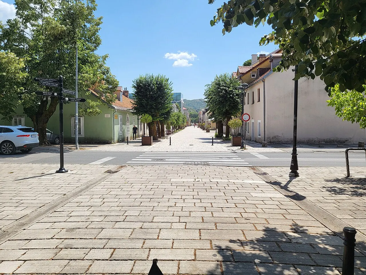 Cetinje's quiet tree-lined pedestrian street lined with low pastel royal-era buildings and pollarded trees