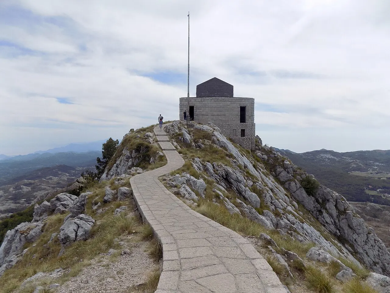 The Njegos Mausoleum on its Lovcen peak, a stone path leading up, mountains spread beyond