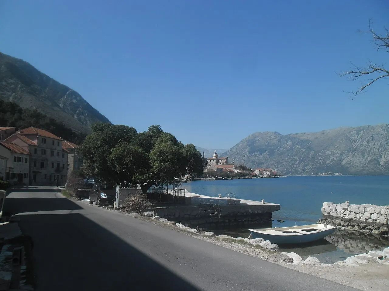 View across the Bay of Kotor from the calm Prčanj shore toward the bay and mountains