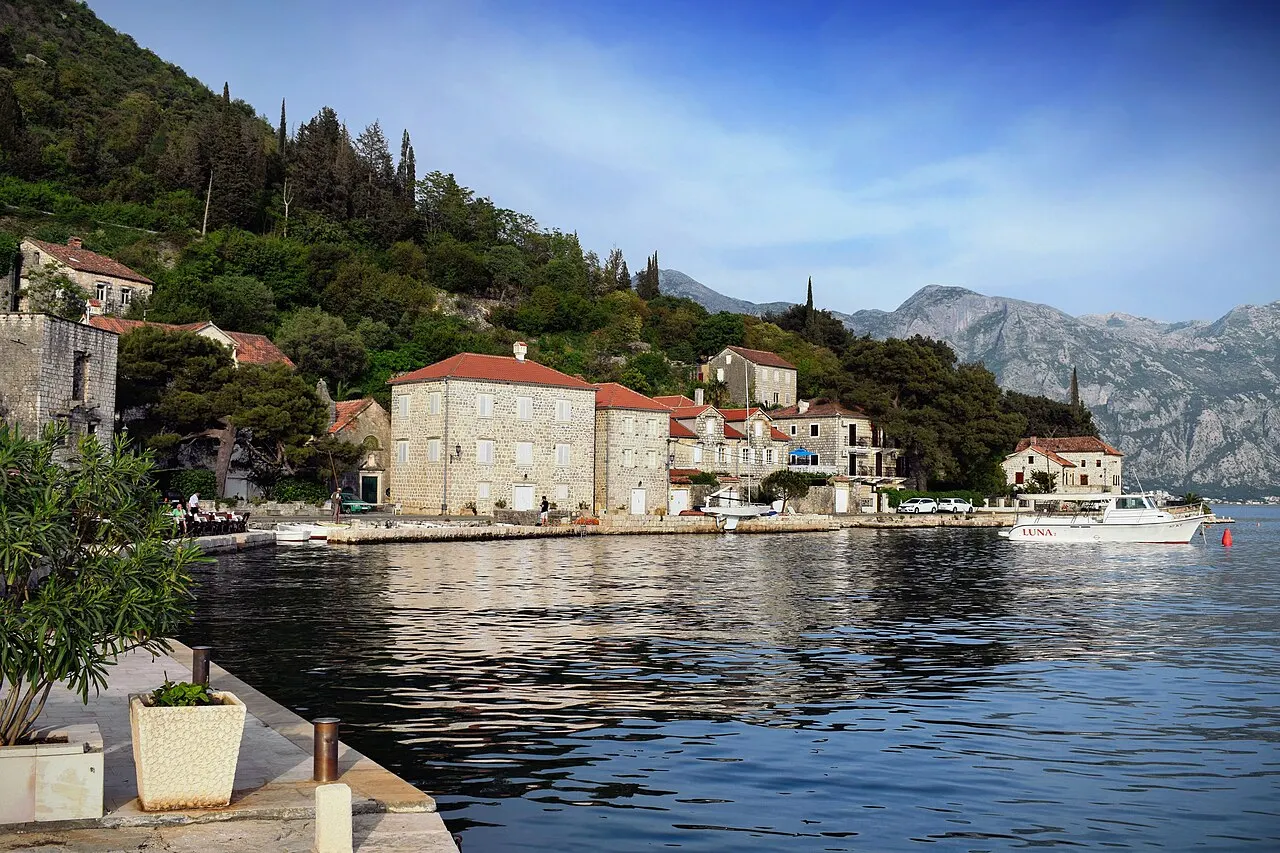 Perast waterfront on the Bay of Kotor with the island church offshore and boats on the bay