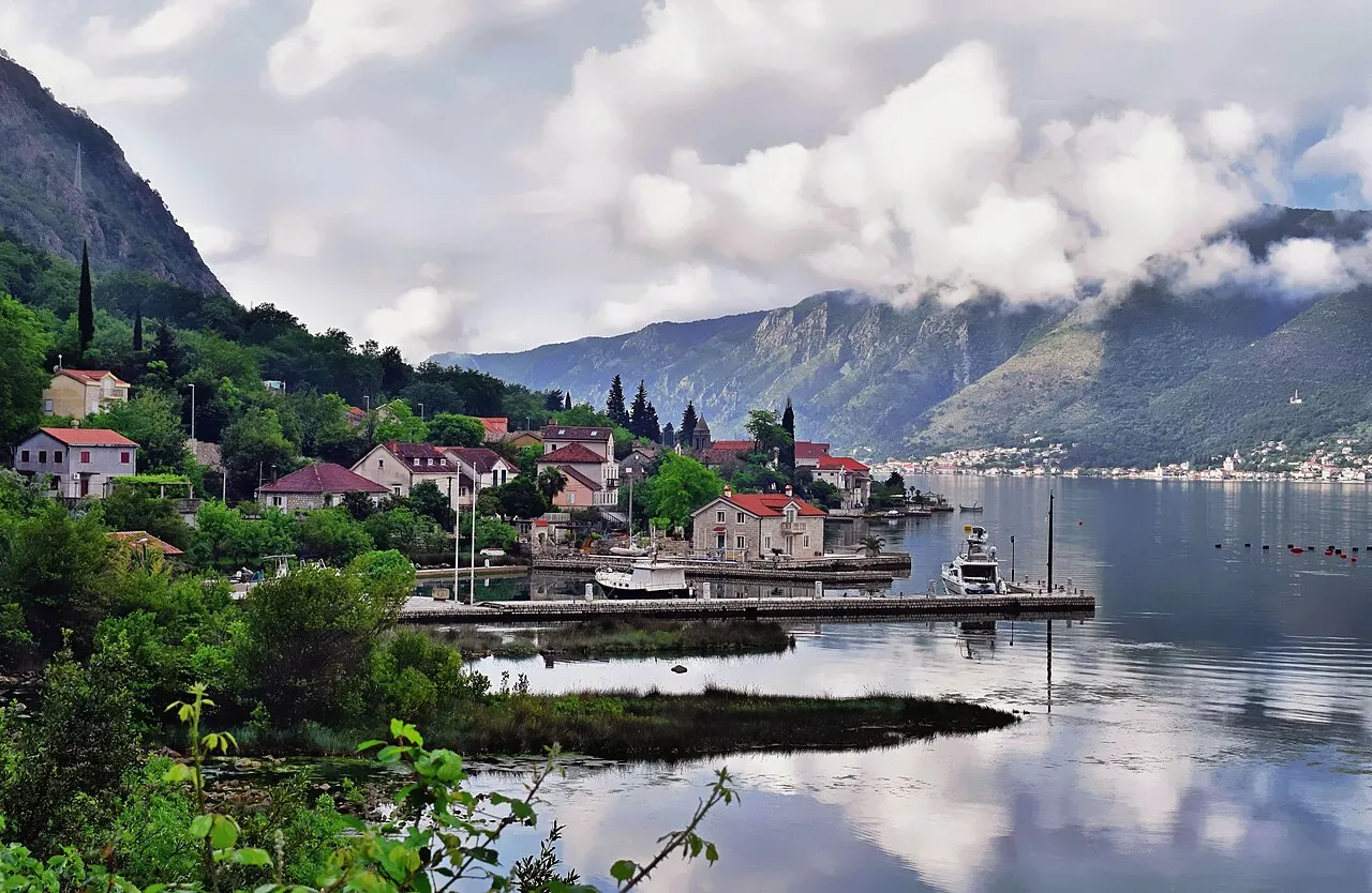 Waterfront houses at Dobrota on the calm Bay of Kotor, mountains and the distant town beyond