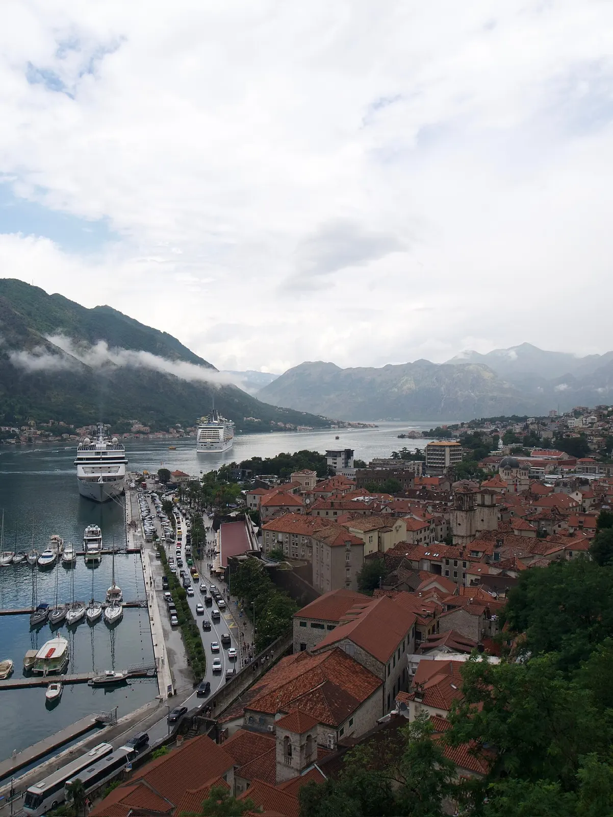Cruise ships on the still Bay of Kotor ringed by mountains, seen from above