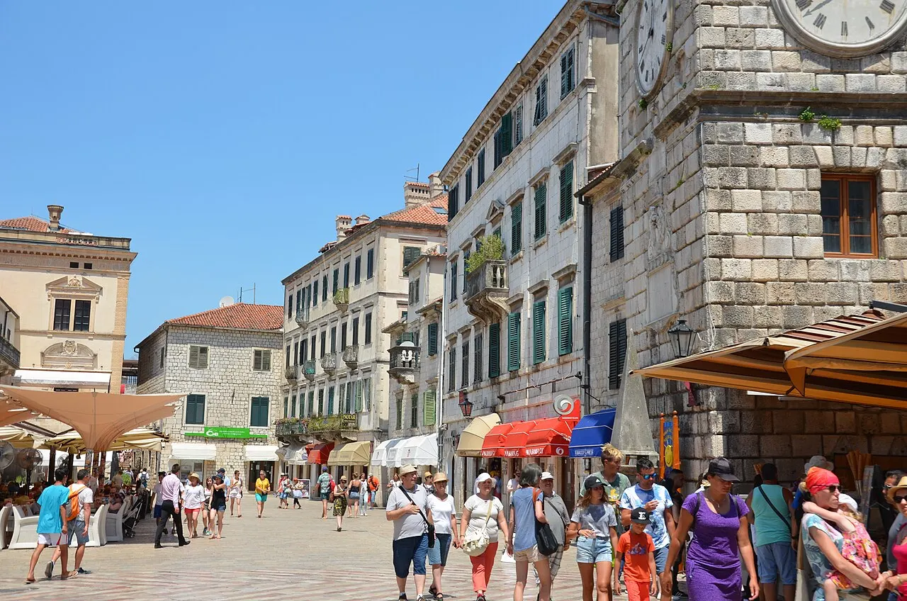 Visitors strolling the busy pedestrian Arms Square in Kotor's Old Town below the Clock Tower