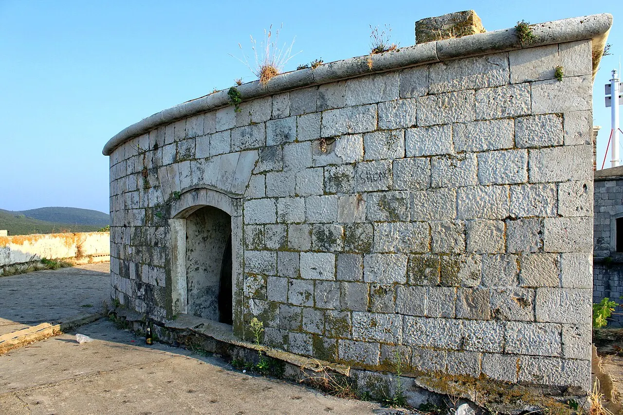 Restored ashlar stonework of Fort Mamula glowing in low golden light