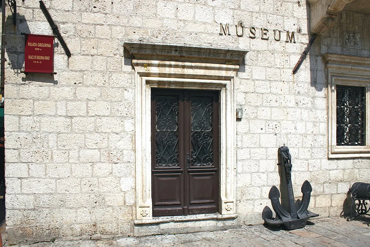 The signposted MUSEUM doorway and anchor at the Grgurina Palace entrance, Kotor