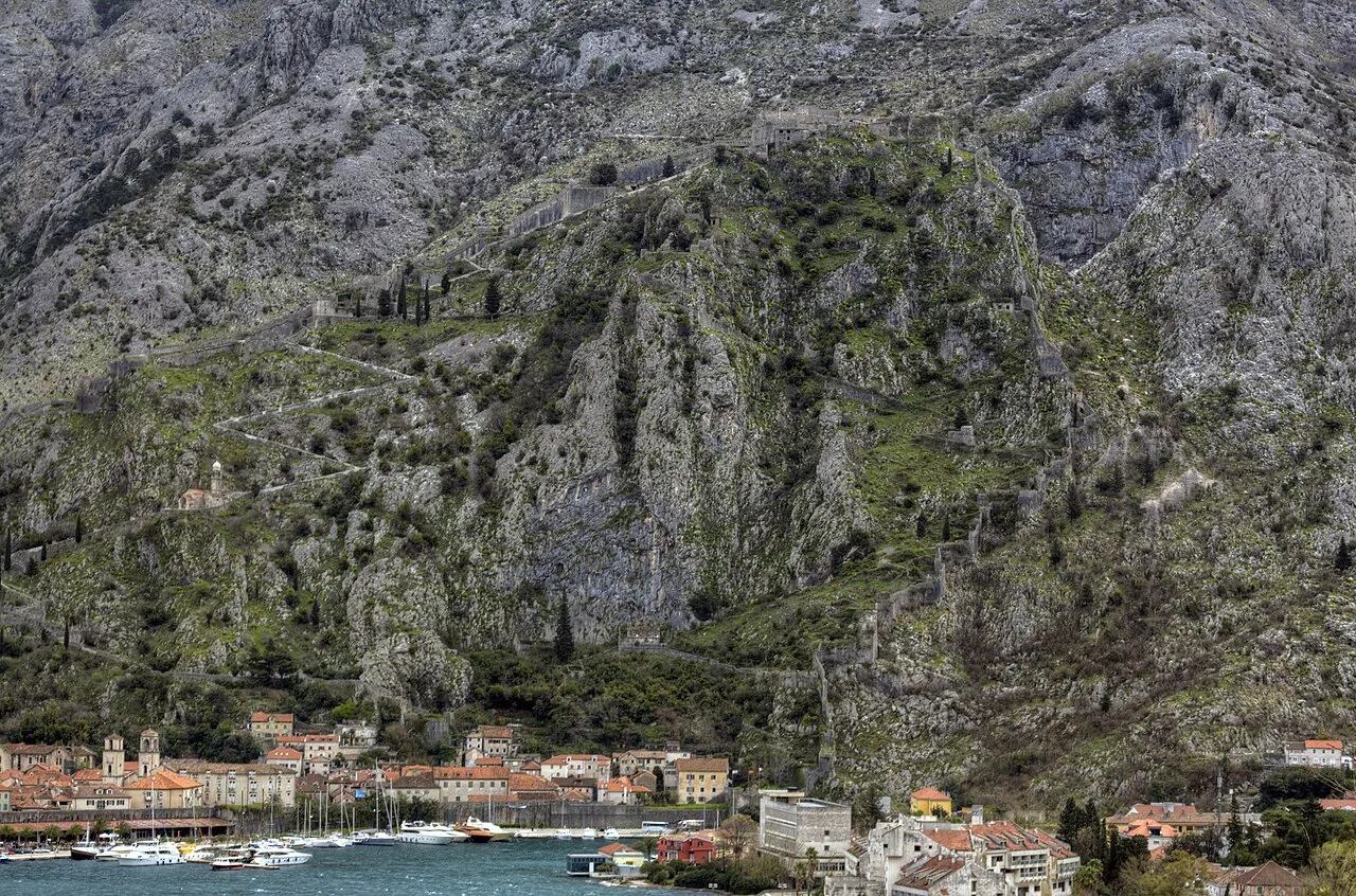 Kotor's old town and the fortress walls climbing the mountain, seen across the bay from Muo