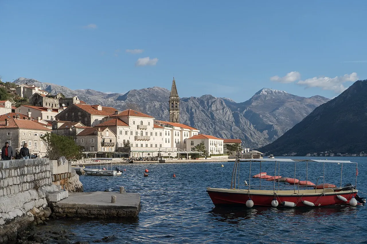 Small boats on the calm Bay of Kotor water at Perast beneath the mountains