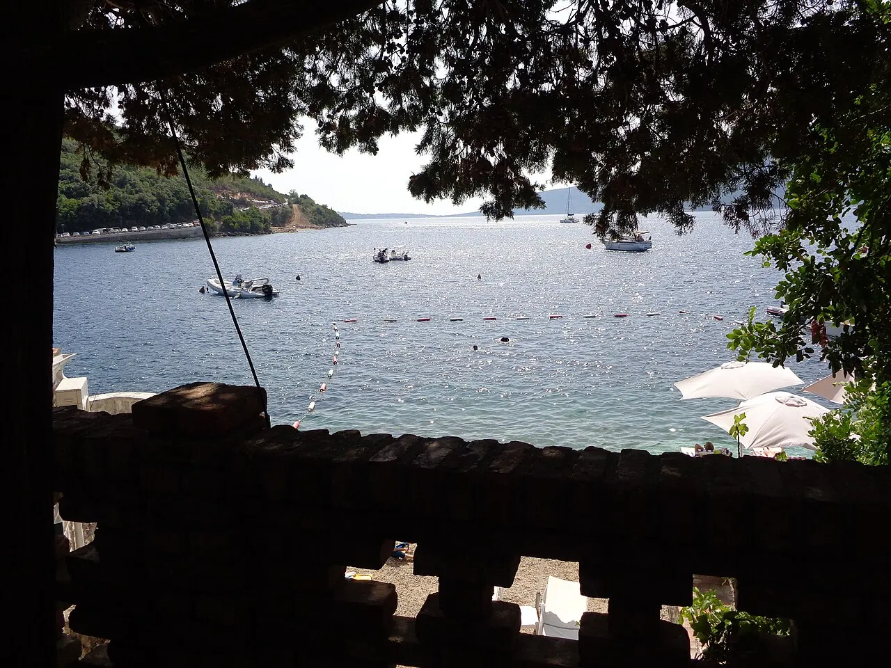 Looking out across the bay mouth from Rose, boats moored offshore and the far shore beyond