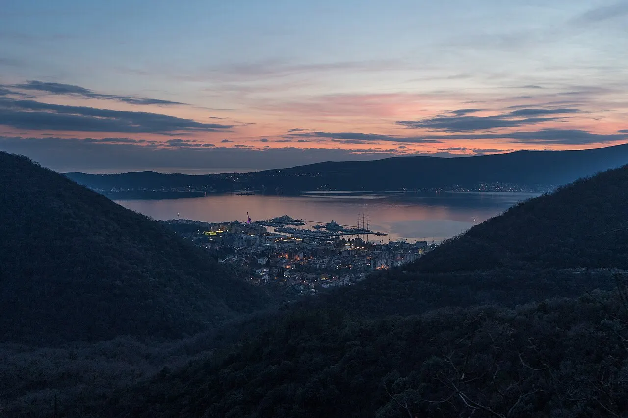 The sun dropping behind the mountain ridge over the Bay of Kotor