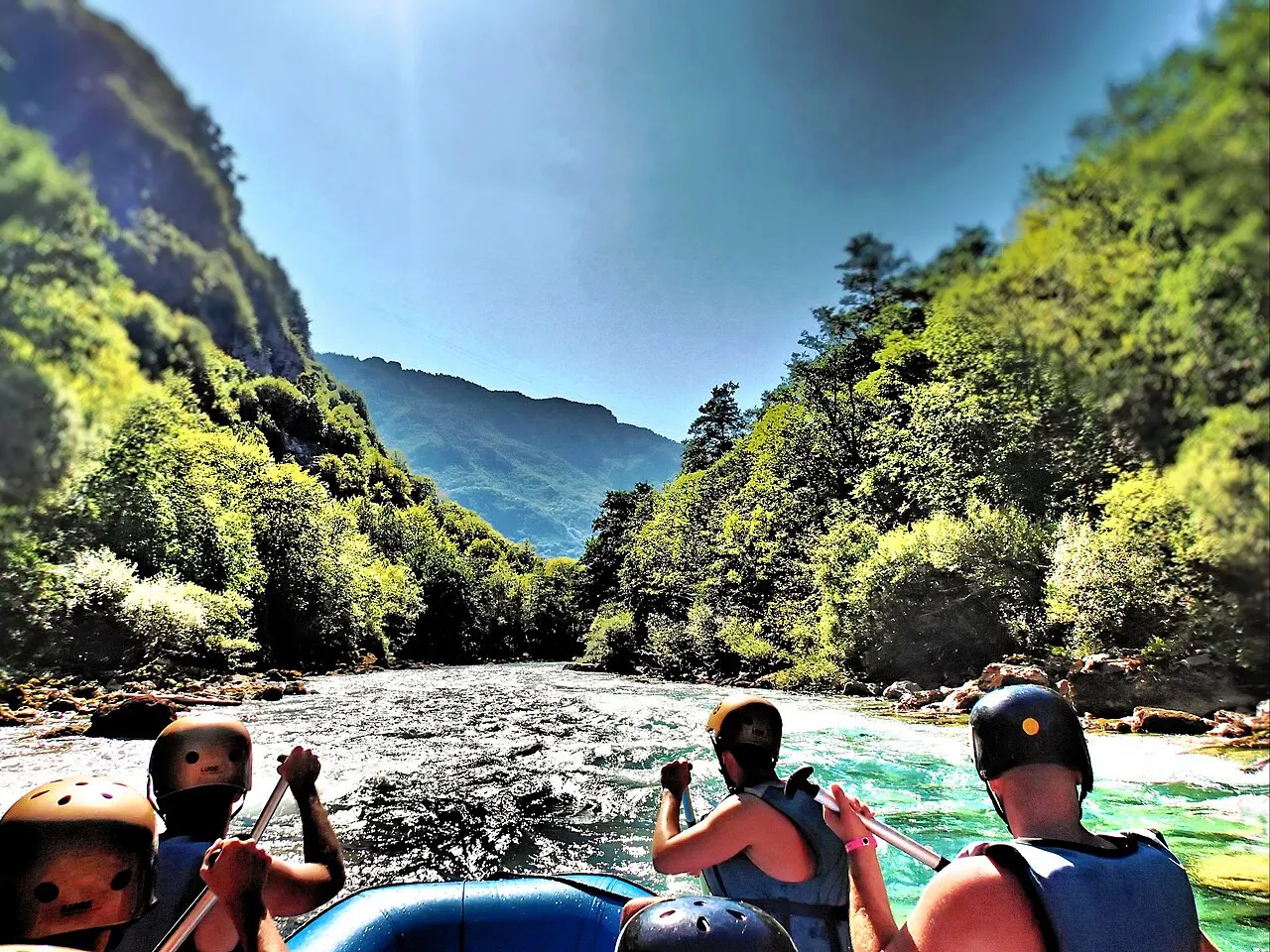 A raft running white water on the emerald Tara River below the canyon walls