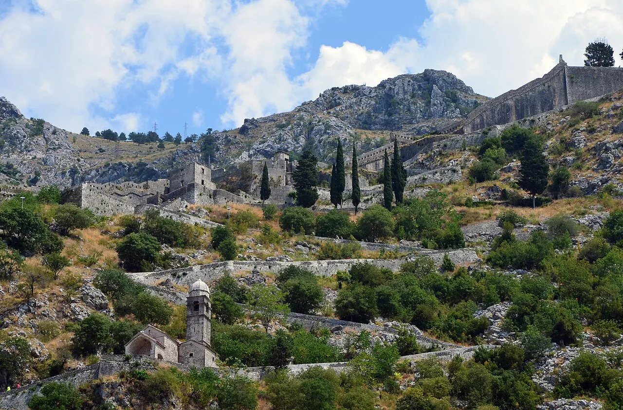 Kotor's city walls and ramparts zig-zagging up the steep cliff toward St John Fortress above the Old Town