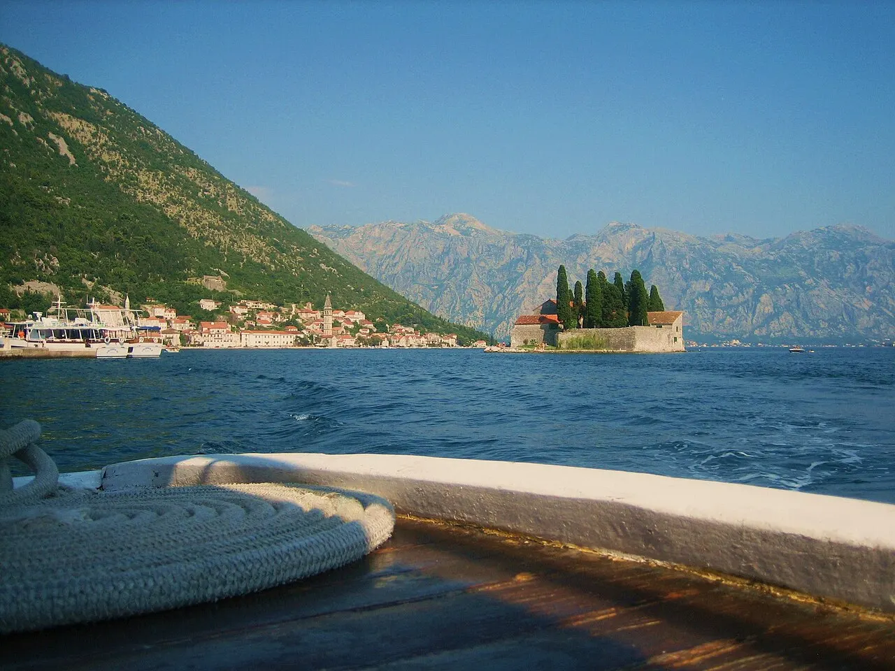 View from a boat on the Bay of Kotor toward Sveti Đorđe island and Perast with its bell tower, mountains behind