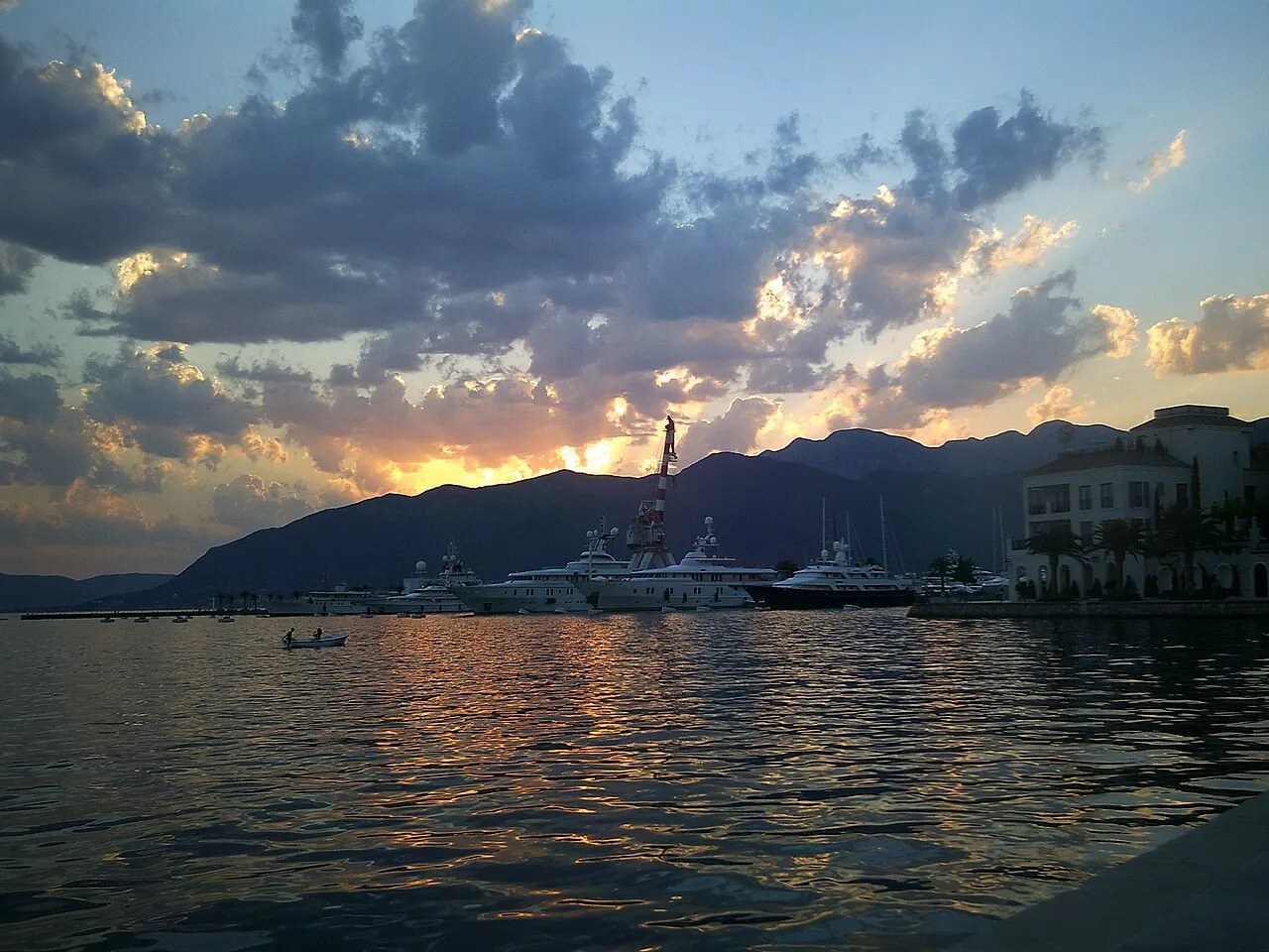 The Tivat waterfront and Porto Montenegro marina at sunset, the bay opening toward the sea